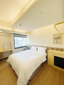 台北小隐居 Hermit Dorm的卧室设有一张白色大床和一扇窗户。