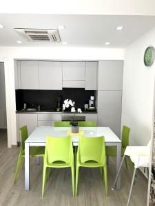 瓦拉泽Green House Varazze的一间设有白色桌子和绿色椅子的用餐室