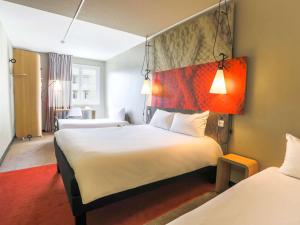 圣艾蒂安Ibis Saint Étienne - La Terrasse的酒店客房带一张大床和两张床
