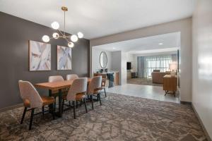 阿尔伯克基Embassy Suites by Hilton Albuquerque的用餐室以及带桌椅的起居室。