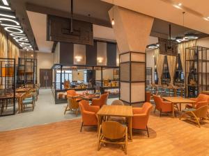 塞恩ibis Thane - An Accor Brand的一个带桌椅的大堂和一间餐厅