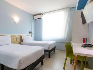 马瑙斯马瑙斯高旅馆的客房设有两张床、一张桌子和一个窗户。