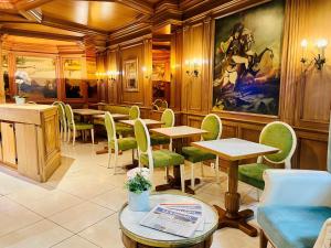 巴黎穆拉酒店的餐厅设有桌椅,墙上挂有绘画作品
