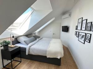 卡尔斯鲁厄Stylisches Apartment in zentraler Lage - mit Klima的白色的卧室设有床和窗户