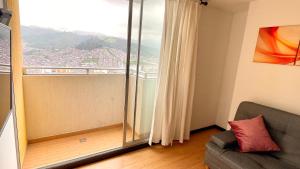 马尼萨莱斯Av santander apartamento perfecta ubicación的带沙发和大窗户的客厅