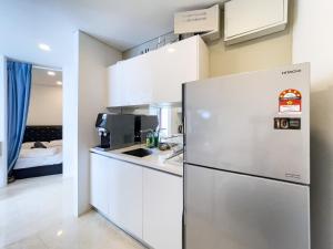 吉隆坡Vortex KLCC Suites by Homestay的白色的厨房配有冰箱和床。