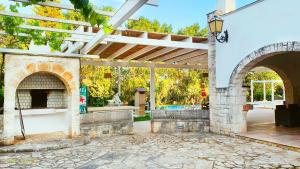 卡洛维诺Villa Gavida的户外庭院设有石制壁炉和遮阳篷。