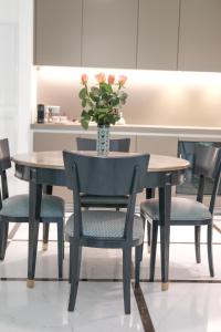 卢森堡The Executive Residence - Kirchberg的一张桌子、椅子和一个花瓶
