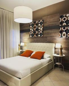 博洛尼亚Central Suite Bed&Breakfast的卧室配有带橙色枕头的大型白色床