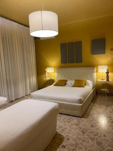 博洛尼亚Central Suite Bed&Breakfast的黄色墙壁客房的两张床