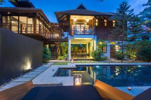 清迈Tolani Northgate Villa Chiang Mai的房屋前有游泳池的房子