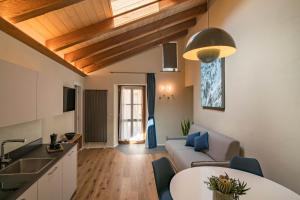 奥斯塔Aosta Holiday Apartments - Sant'Anselmo的厨房以及带沙发和桌子的客厅。