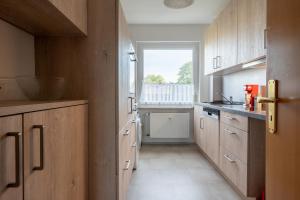 汉诺威Private Apartment的厨房配有木制橱柜和窗户。