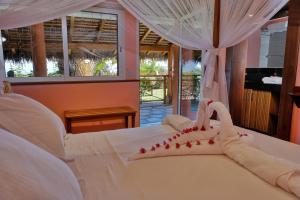 贝岛VILLA PANORAMA NOSY BE的卧室配有白色床和红色装饰