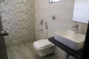 甘德希罕Hotel Grand Ambience的浴室配有白色卫生间和盥洗盆。
