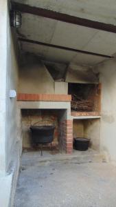 LannaLA CASA DEI RICORDI的砖砌壁炉,上面有两个黑锅