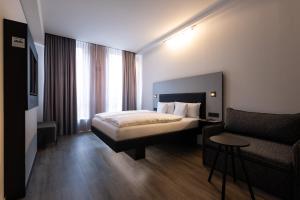 埃斯林根GINN Apartment-Hotel Stuttgart-Esslingen的酒店客房,配有床和沙发