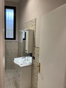 米兰Cozzi Apartment的白色的浴室设有水槽和窗户。