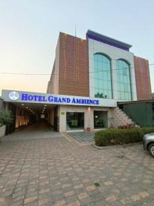 甘德希罕Hotel Grand Ambience的酒店宏伟的入口,前面设有停车场