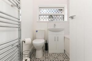 Great CoatesModern home near Alexandra Dock的白色的浴室设有卫生间和水槽。