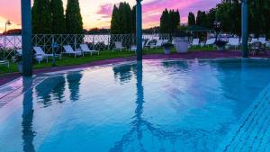 纳坦利纳坦利温泉酒店的一个带椅子的游泳池,享有日落美景