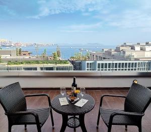 伊斯坦布尔博斯普鲁斯港酒店的阳台上配有一张桌子和两把椅子,并提供一瓶葡萄酒