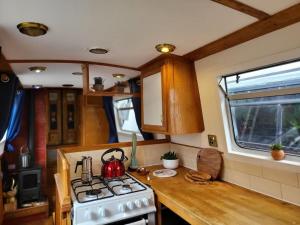 伦敦Cosy Canal Boat in Little Venice by Paddington for Family & Friends的厨房配有炉灶,台面上配有茶壶