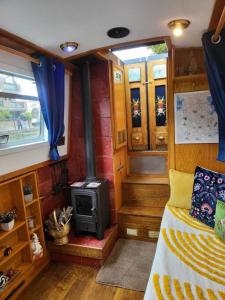 伦敦Cosy Canal Boat in London Centre for Family & Friends的客房设有一张床和一个燃木炉