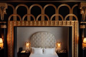 巴黎Maison Souquet, Hotel & Spa的一间卧室配有一张带金色框架的白色床
