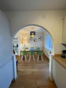 BaconsthorpeCharming North Norfolk flint cottage的厨房以及带桌子和绿色椅子的用餐室。