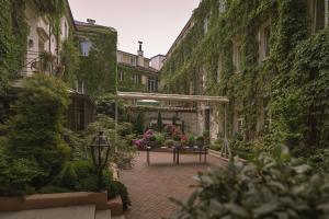 维尔纽斯瑞莱沙托斯思提吉莱堡酒店的一座庭院,里面种有植物和花卉