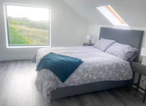 Shannon Castle Holiday Cottages - Type D的一间卧室设有一张大床和一个窗户。