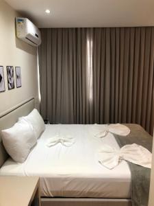 坎普斯戈伊塔卡济斯Apart-hotel TrueAmérica的酒店客房,配有白色床单