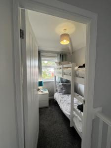 曼彻斯特Modern 3-bed stay-away-home sleeps 6 nr Manchester的一间卧室设有两张双层床和一扇窗户。