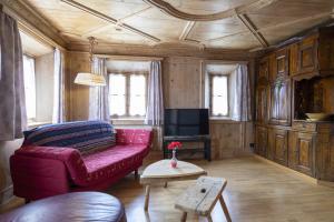 阿尔代兹Chasa Broel Ferienhaus mitten in Ardez的客厅配有红色沙发和电视