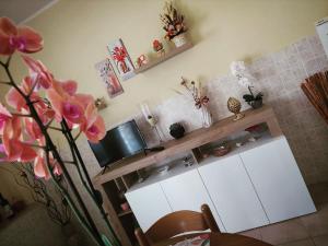 MacchiagodenaB&B da Manuela的厨房配有白色橱柜和鲜花柜台。