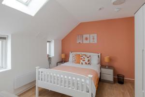 伦敦Wonderland - Fitzrovia - by Frankie Says的卧室配有白色的床和橙色的墙壁