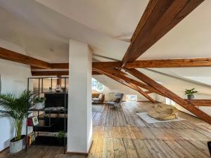 基姆湖畔普林Loft-Wohnung im Herzen von Prien - 100m2 - SmartTV的阁楼客厅设有木制天花板和木地板