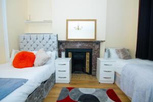 伦敦Victorian Woods BnB的客厅设有两张床和壁炉
