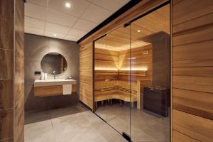 吕伐登Van der Valk Hotel Leeuwarden的一间带玻璃淋浴和水槽的浴室