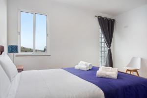 卡列塔Simão House的一间卧室配有一张大床和两条毛巾