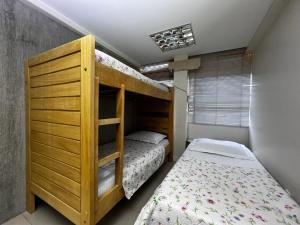 巴西利亚Hospedagem BRASILIANAS的卧室配有双层床,位于床边。