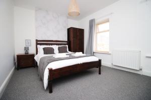 卡迪夫Central Cardiff - 3 Bedroom Home - Free Parking - Walk to Shopping Town Centre And Cardiff Castle的一间卧室设有一张大床和一个窗户。