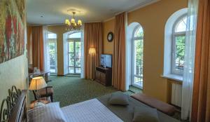 波尔塔瓦帕拉佐普瑞米尔酒店的一间卧室设有一张床、一台电视和窗户。