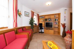卡瓦莱塞曼努埃拉加尼旅馆的一间设有红色椅子和电视的等候室