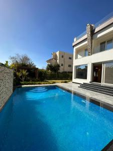 Sheikh ZayedAl Sawah Stand Alone Villa With Private Pool的一座大蓝色游泳池,位于房子前