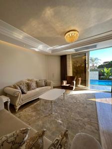 Sheikh ZayedAl Sawah Stand Alone Villa With Private Pool的客厅配有沙发和桌子