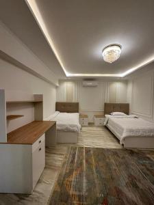 Sheikh ZayedAl Sawah Stand Alone Villa With Private Pool的一间卧室配有两张床和吊灯。