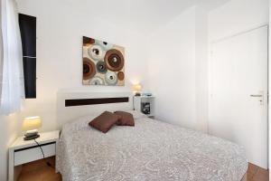 拉戈斯Mdc - Muralhas da Cidade的白色卧室配有一张床,墙上挂着一幅画