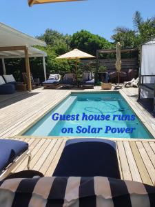 普利登堡湾Long Story Guest House的一座游泳池,上面标有读取旅馆的标志,使用太阳能供电